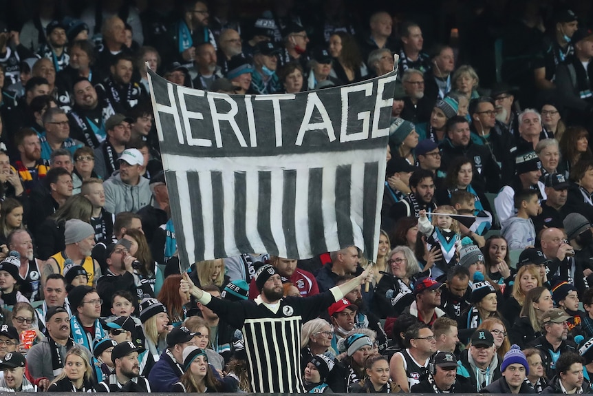A fan in the crowd holds a banner that says heritage
