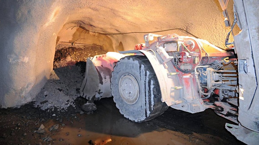 A machine collects material from within an underground mine.
