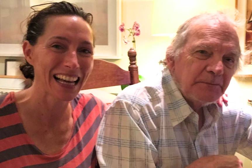 Claudia Karvan smiles at the camera in a red and grey-striped top, next to her biological dad Peter Robins.