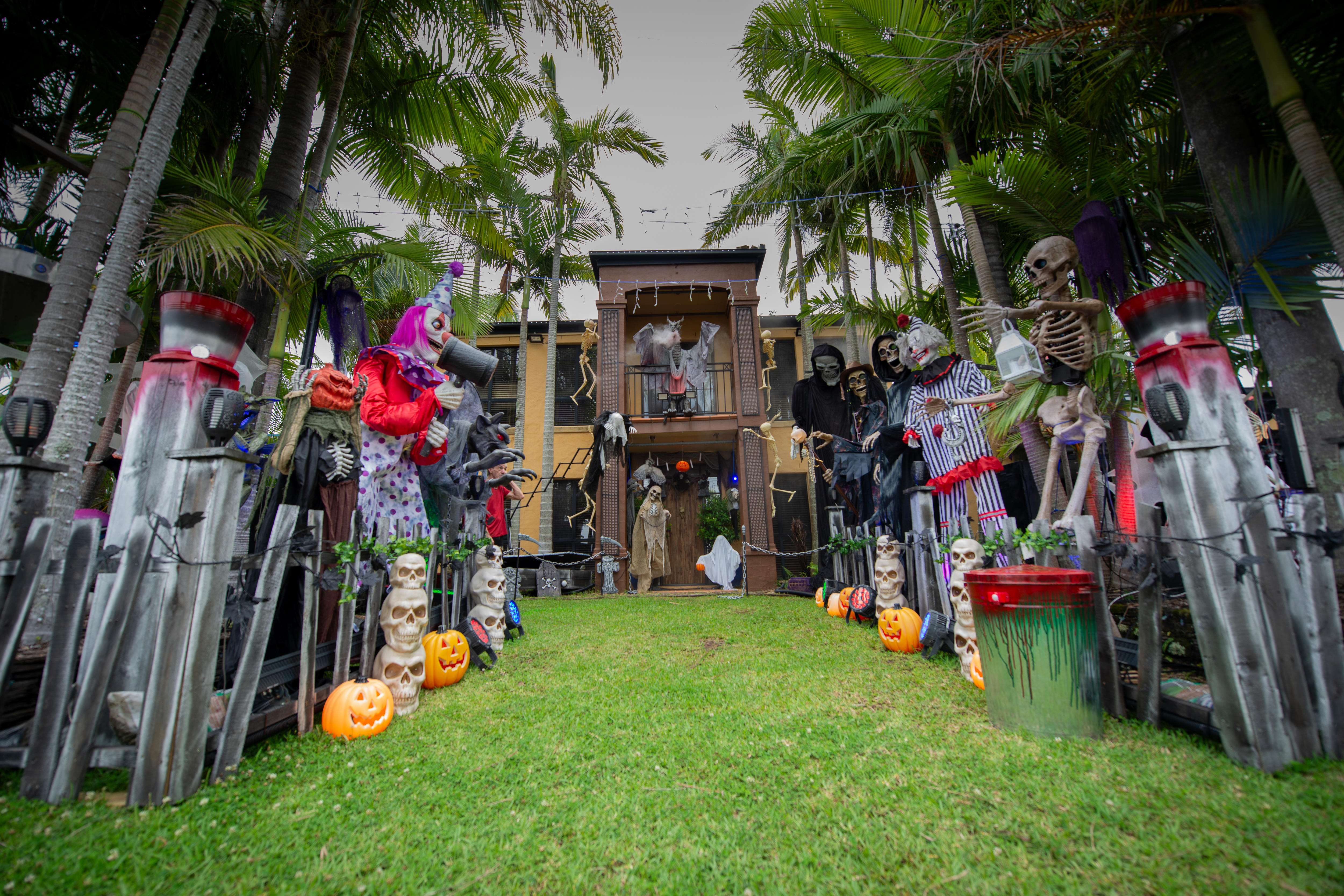A suburban, two-storey home with dozens of Halloween decorations in the front yard.
