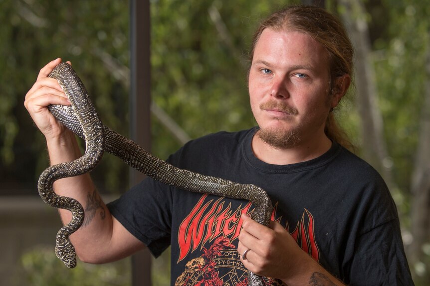 Researcher Damien Esquerre holds a python snake.