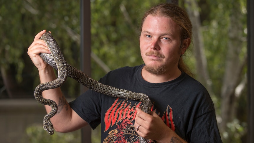 Researcher Damien Esquerre holds a python snake.