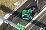 A screenshot from above of a freeway sign on a car.