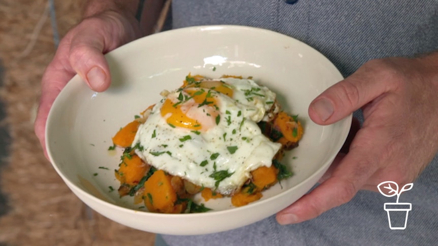 Bowl of fried pumpkin with 2 fried eggs on top
