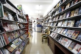 Shopkeepers wait for customers at a store selling DVDs