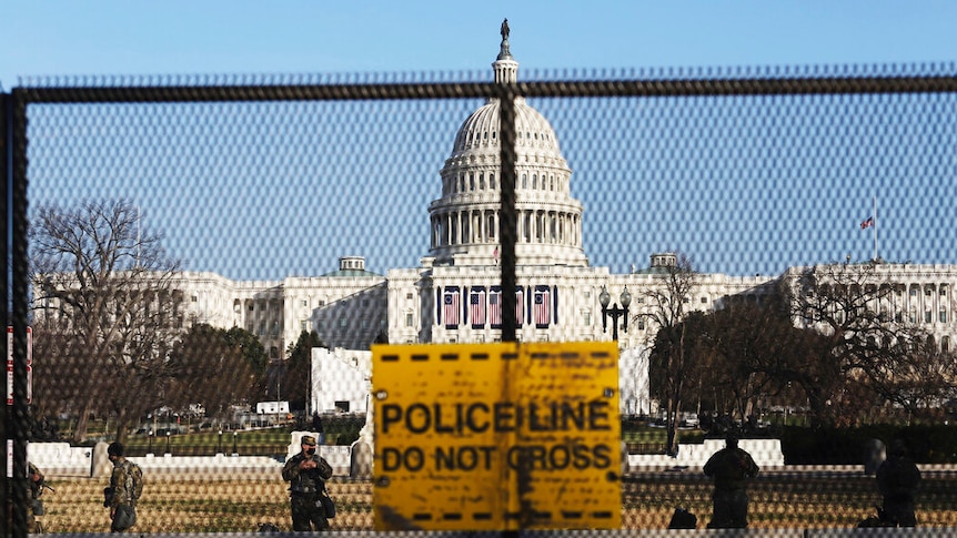 National guards are seen behind a fence that was erected to reinforce security at the Capitol in Washington.