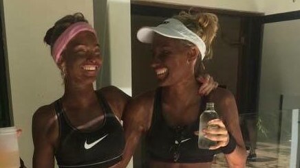 Two young white women seen with blackface dressed in tennis costumes.
