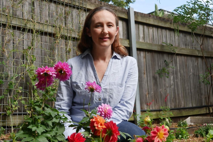 Natalie Shaw stands in a flower garden in a suburban backyard as part of her edible flower business