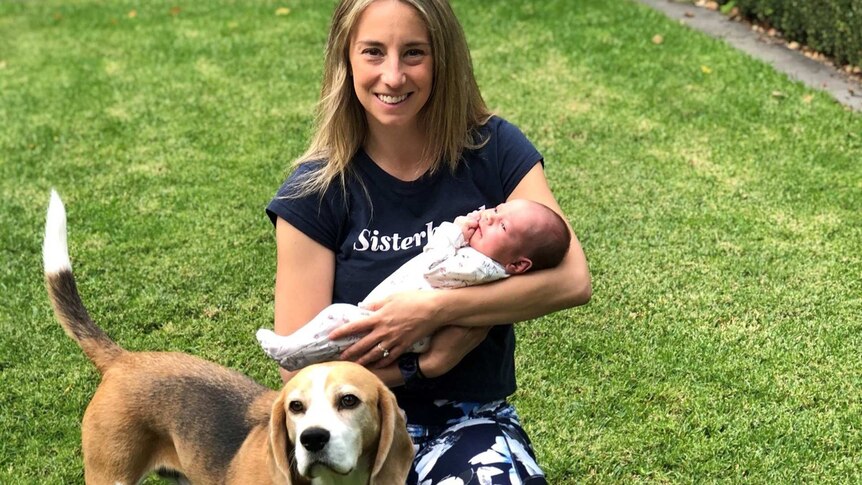 Lena Fultheim with baby Sierra and dog on the lawn in a story about how to support new parents during the coronavirus pandemic.