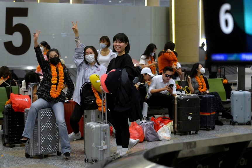 A group of Chinese tourists with their luggage. 