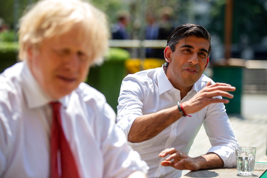 鲍里斯·约翰逊（Boris Johnson）和里希·苏纳克（Rishi Sunak）身着白衬衫坐在外面的一家酒吧里。
