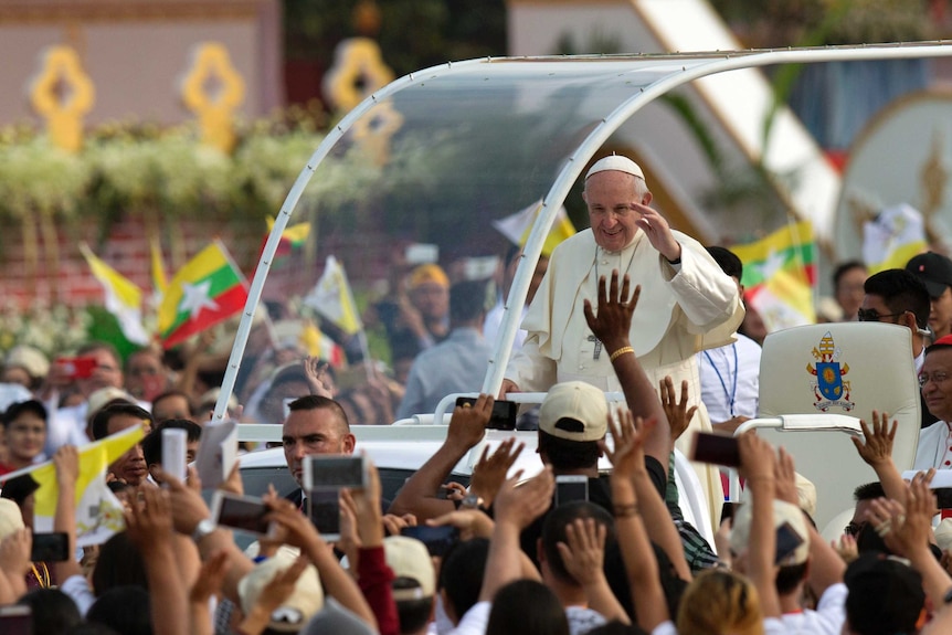 Pope Francis waves from pope-mobile as Myanmar Catholics wave flags