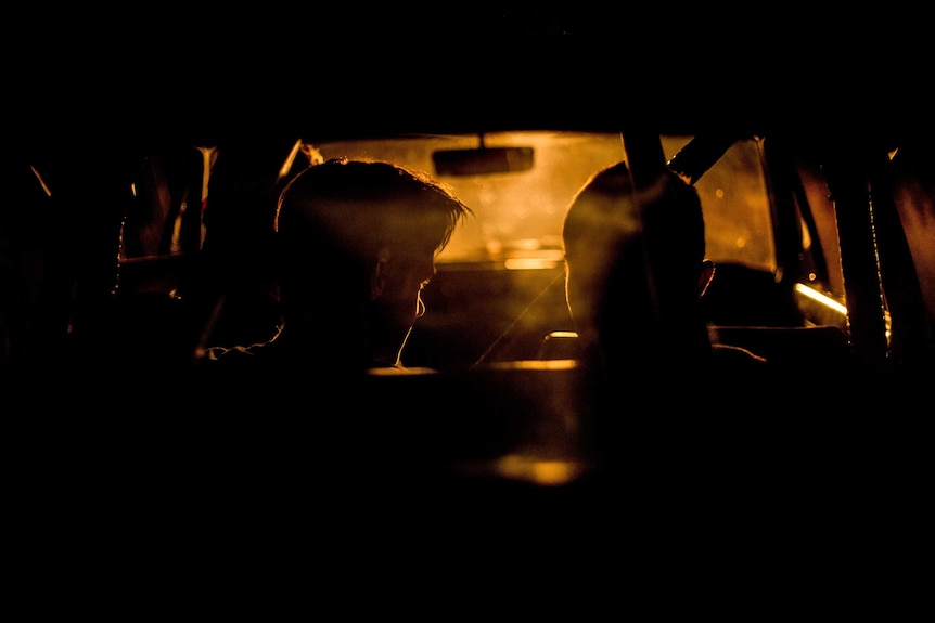 Silhouettes in the back of a car.