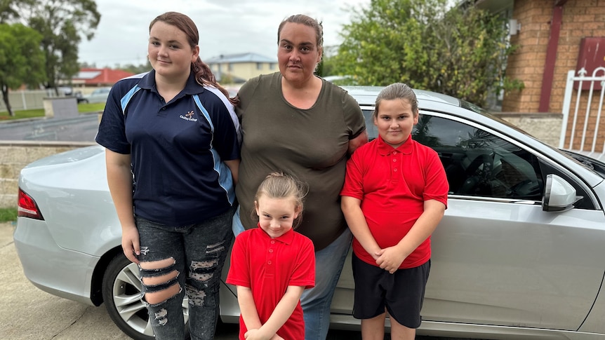 Mother and three children with a car