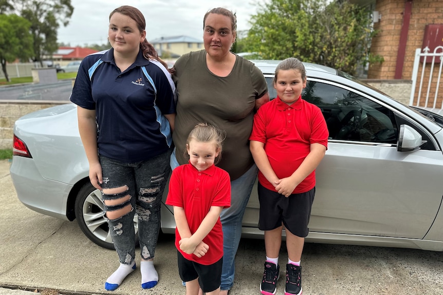Mother and three children with a car