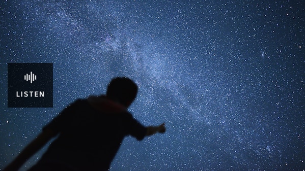 The silhouette of a man pointing up at a starry sky. Has Audio.