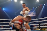 Tim Tszyu stands over Stevie Spark who is bent over in pain