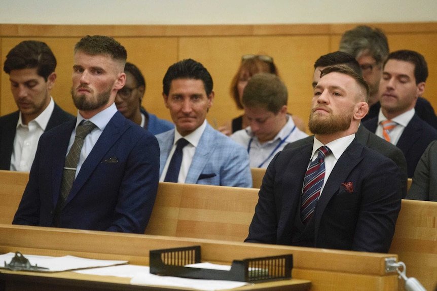 Conor McGregor and Cian Cowley sit in the dock in the court room