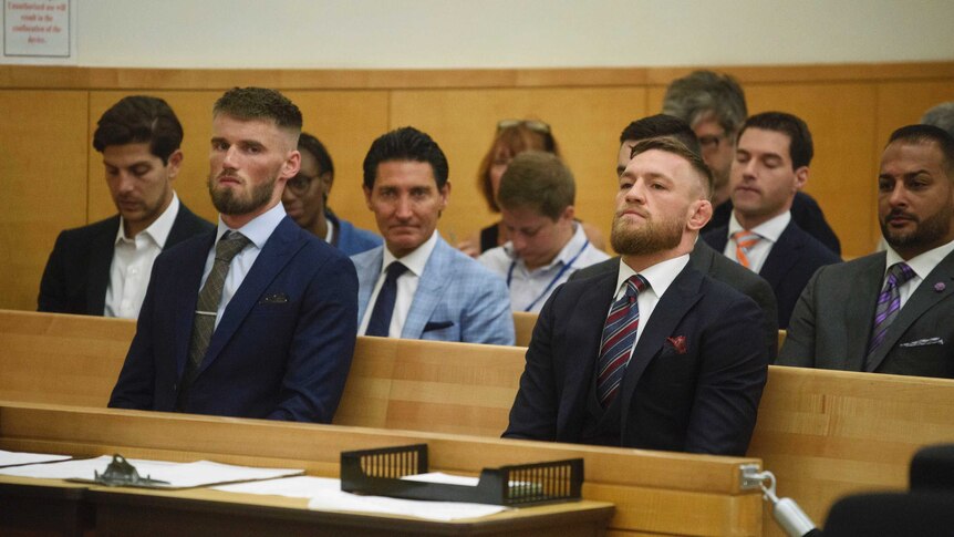 Conor McGregor and Cian Cowley sit in the dock in the court room