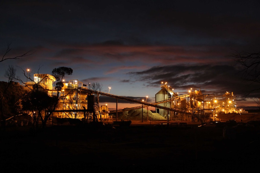 Gold mining operations lit up against the dark night time sky.