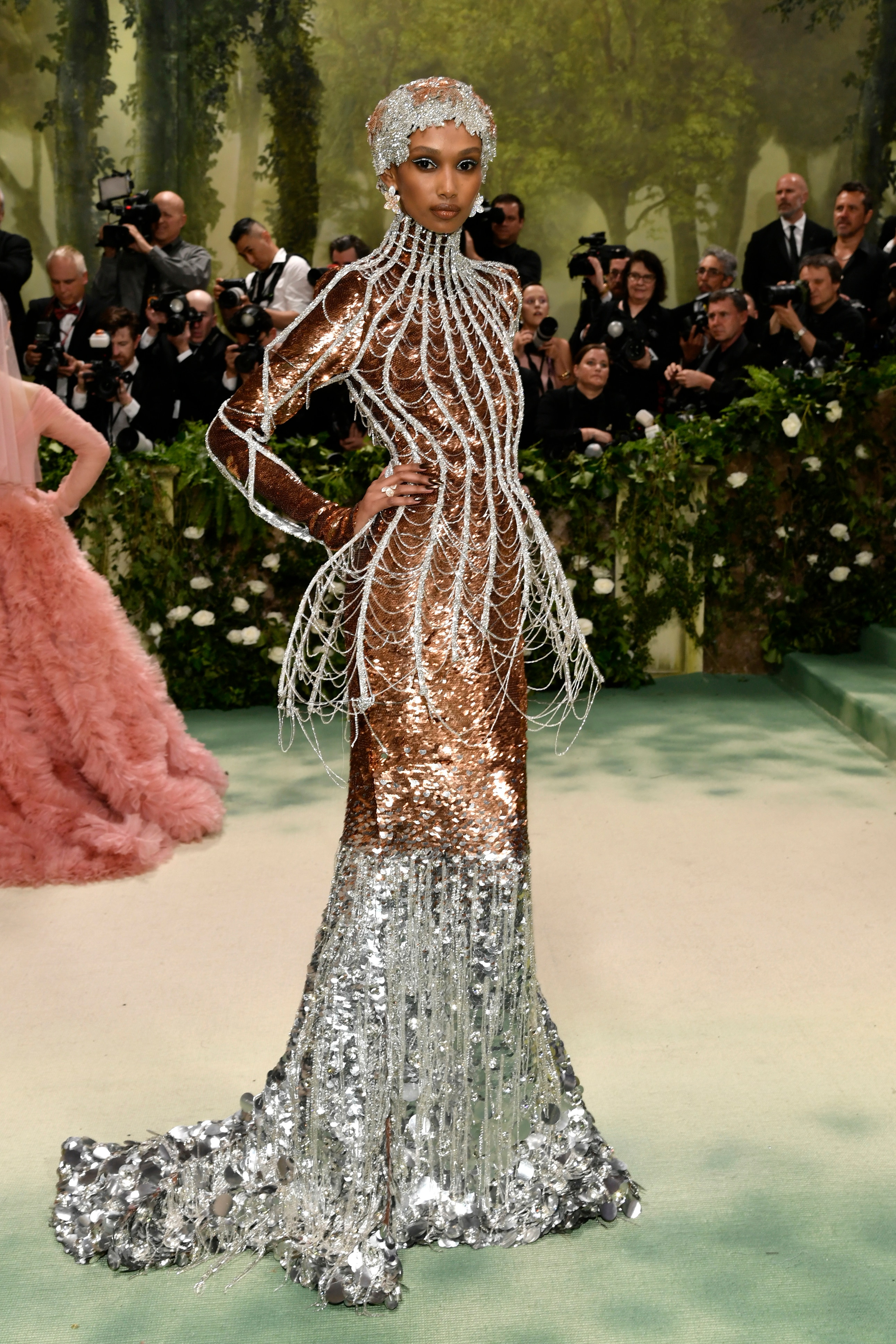 Hanani Taylor wearing wear a bronze shimmery long-sleeved dress with a silver skirt and silver boning and cap