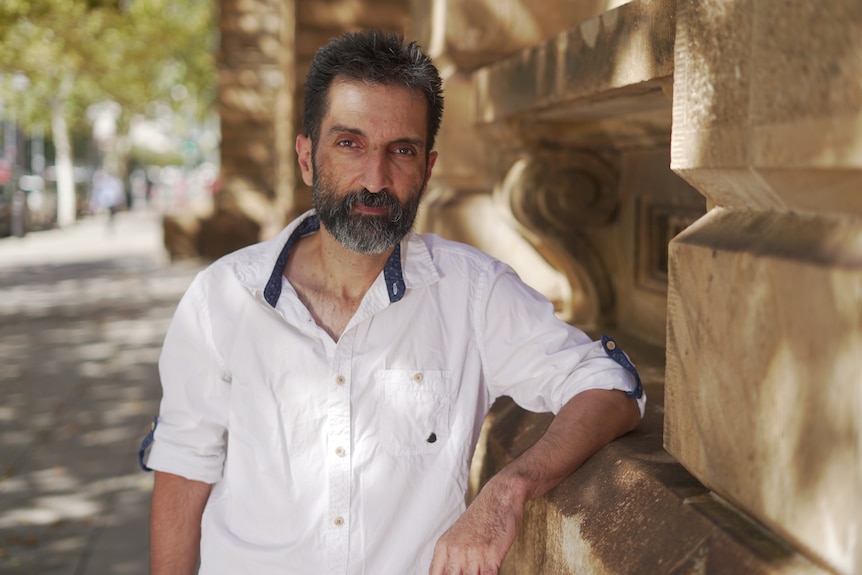 A man with a beard wearing a white shirt