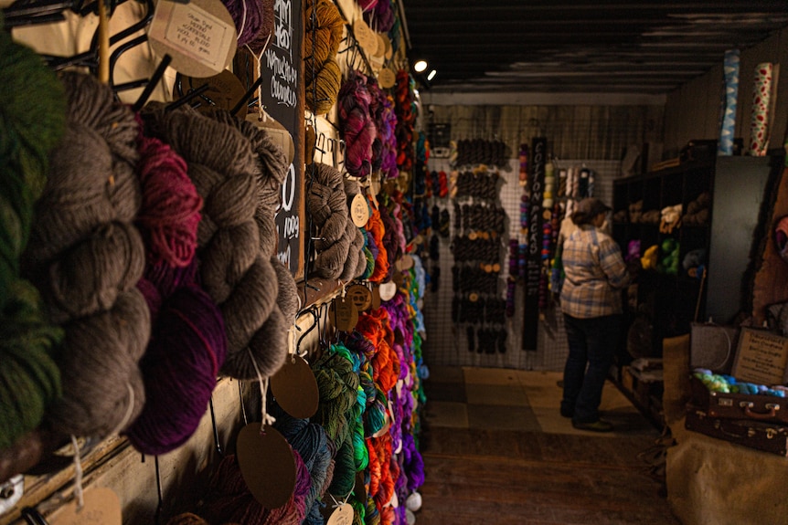 Bundles of wool hang along the wall of the shop