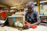 A woman works at a sewing machine