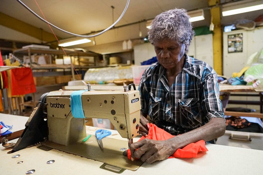 A woman works at a sewing machine