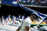 David Warner walks under an Australia flag