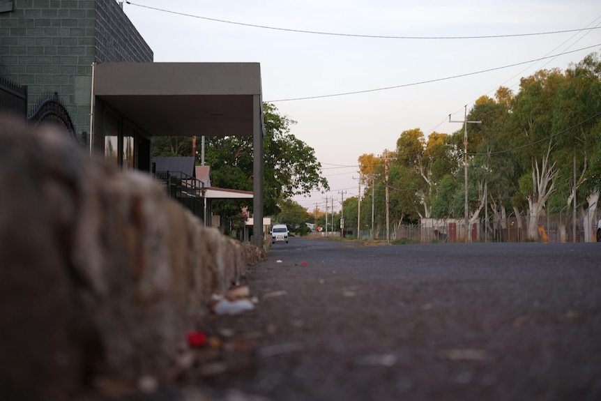 A view of a central thoroughfare in a country town, viewed kerb-side at street level.