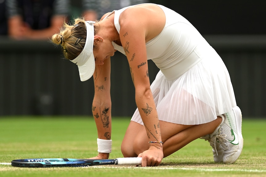 Marketa Vondrousova sinks to her knees on Wimbledon's Centre Court.