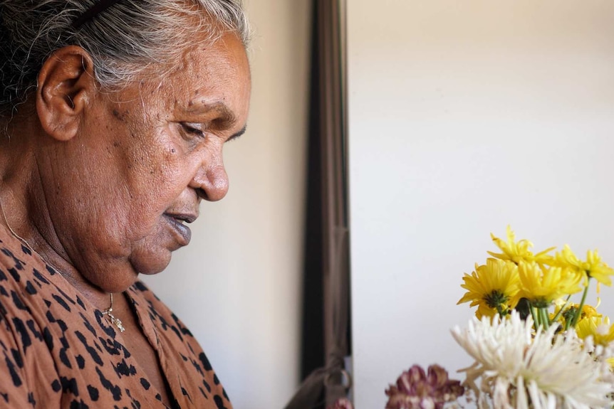 Aboriginal elder Kathy Davis arranging flowers in her Northam home.