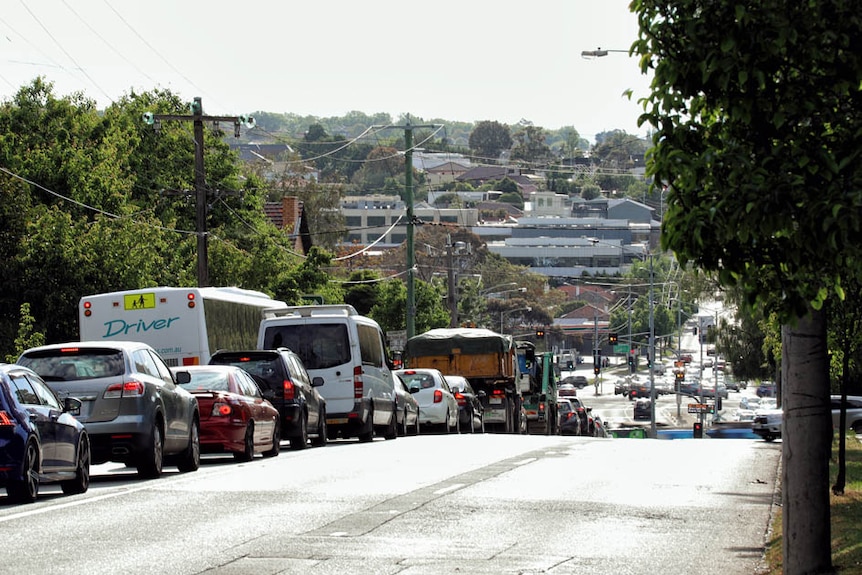 Cars line up at a Toorak Road level crossing.