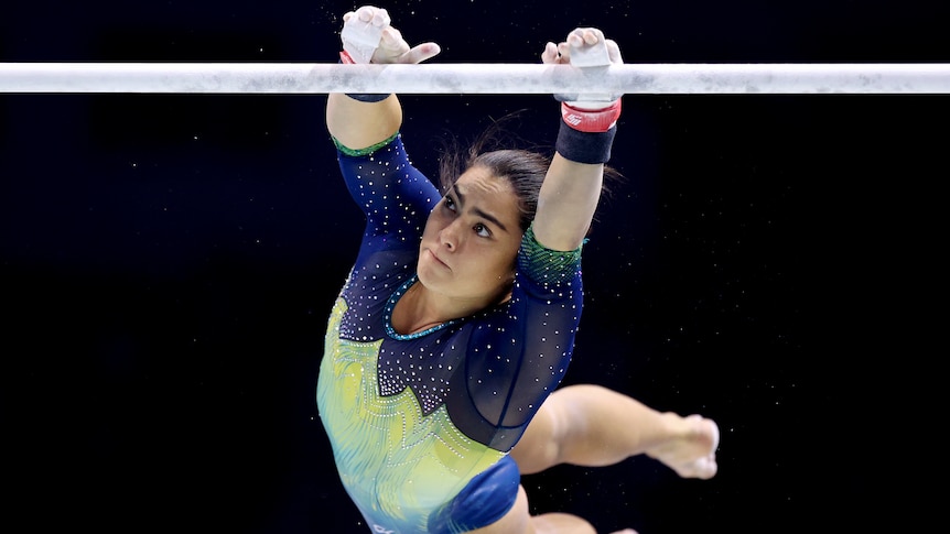 Georgia Godwin catches one of the uneven bars during a gymnastics competition.