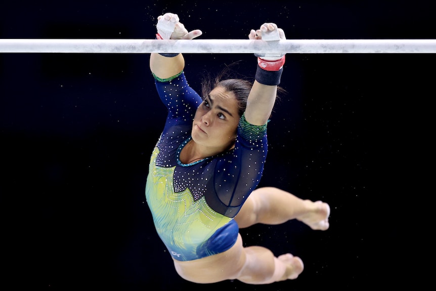 Georgia Godwin catches one of the uneven bars during a gymnastics competition.