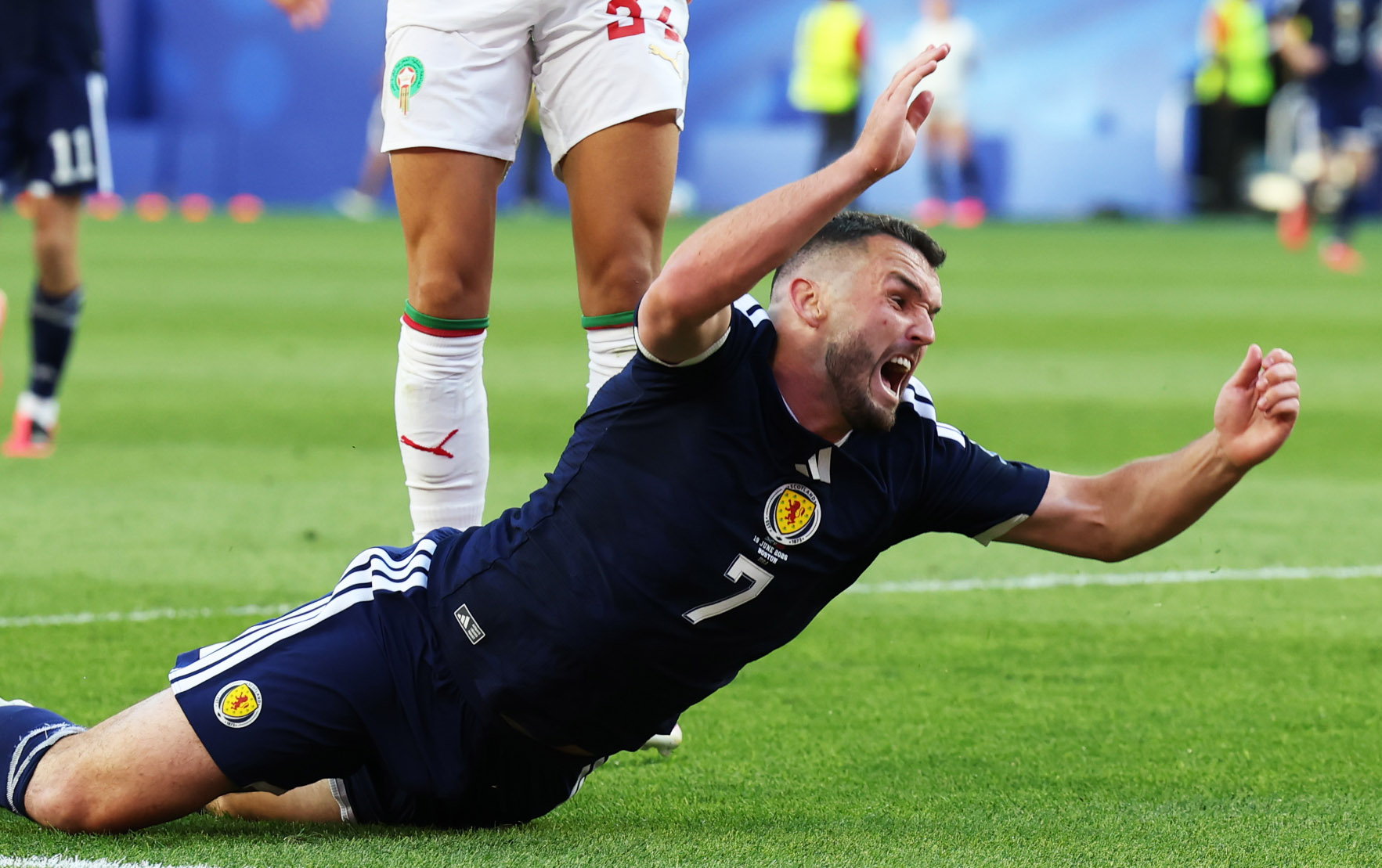 John McGinn dives to the ground while playing for Scotland