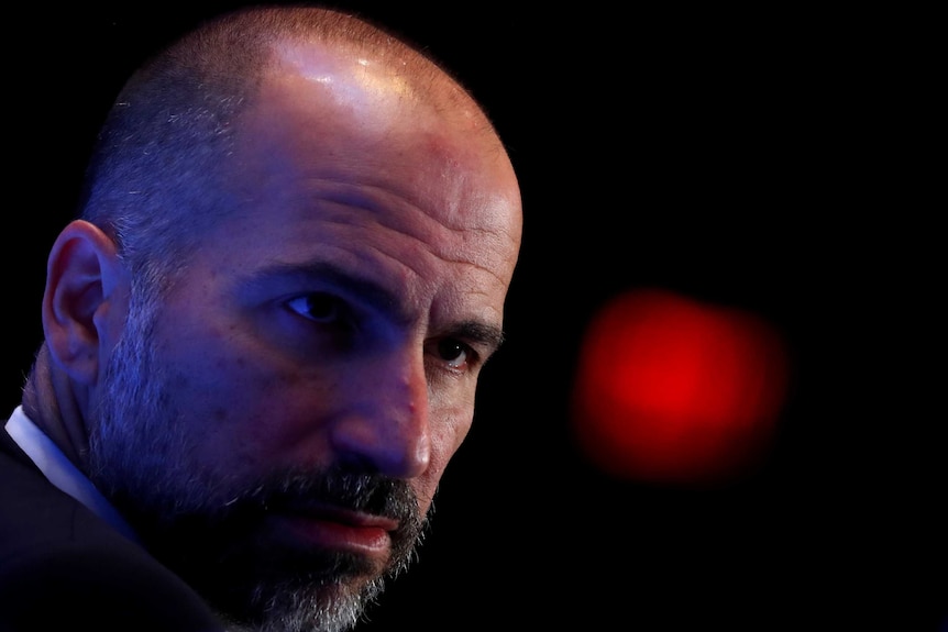 A close up of Uber CEO Dara Khosrowshahi shows him looking serious.