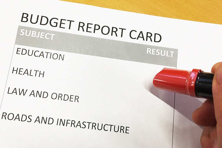 Budget report card with pen hovering overhead.