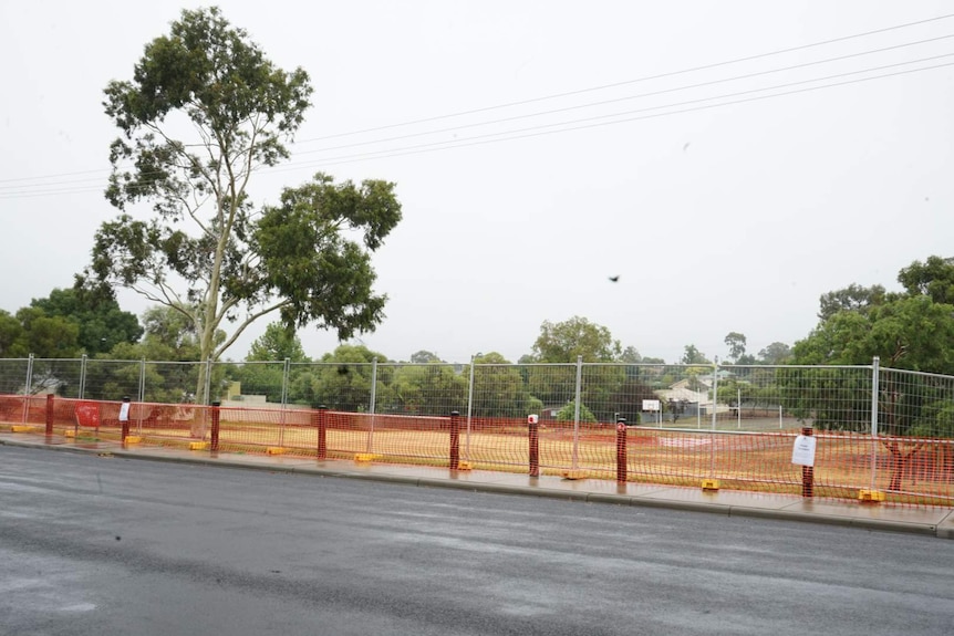 Orange mesh barriers create a barrier between the public and park