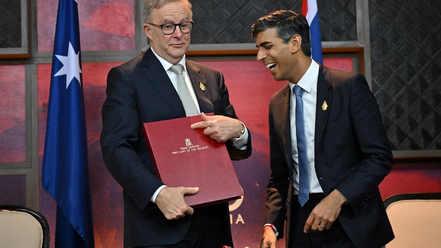 Anthony Albanese holding a red folder and Rishi Sunak laughing