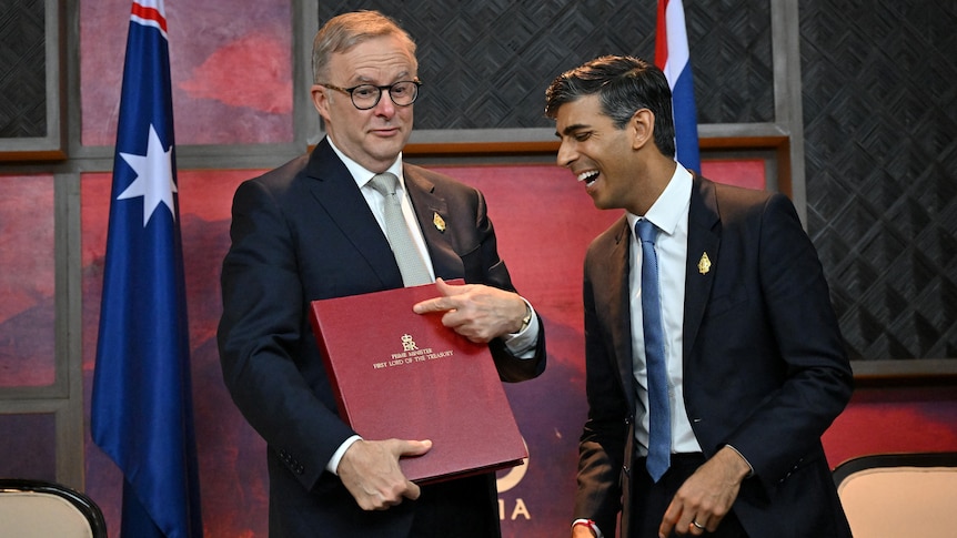 Anthony Albanese holding a red folder and Rishi Sunak laughing