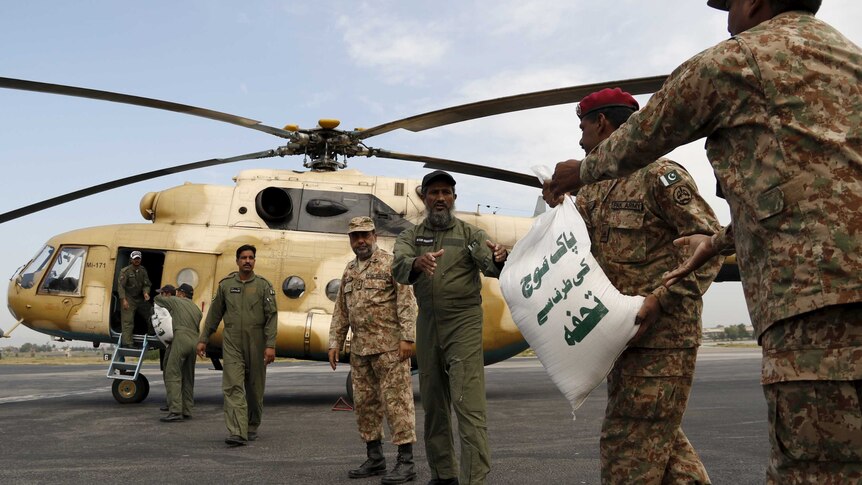 Soldiers load sacks of food aid on a helicopter in Pakistan