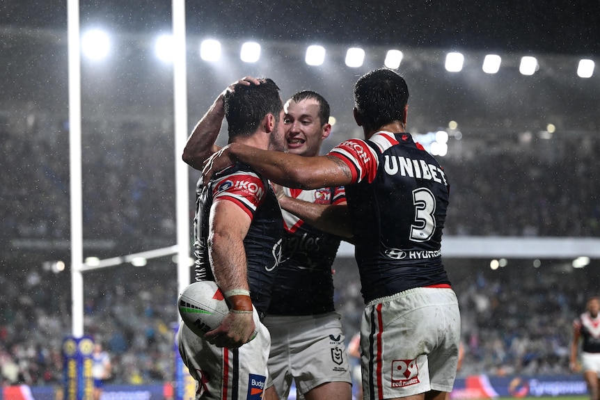 Nat Butcher of the Roosters (left) celebrates with Sam Walker and Fetalaiga Pauga