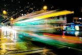 A tram moved through an intersection in Hawthorn on a rainy night.