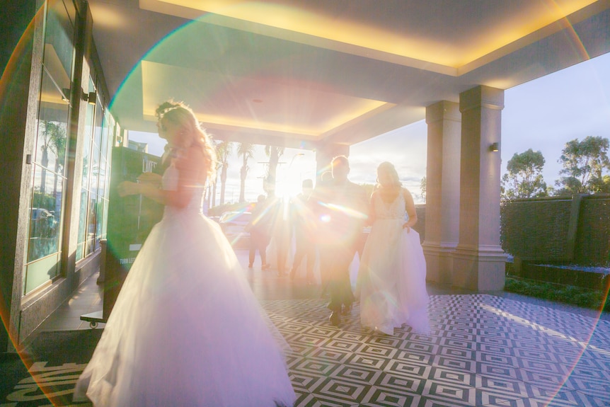 The young couples walk into the reception centre as the sun sets behind them