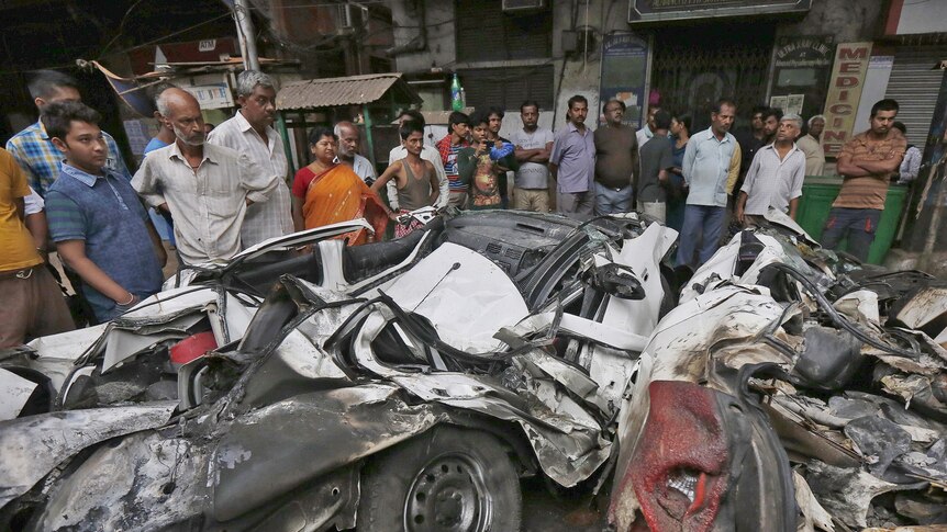 People look at wreckage caused when an under-construction flyover collapsed