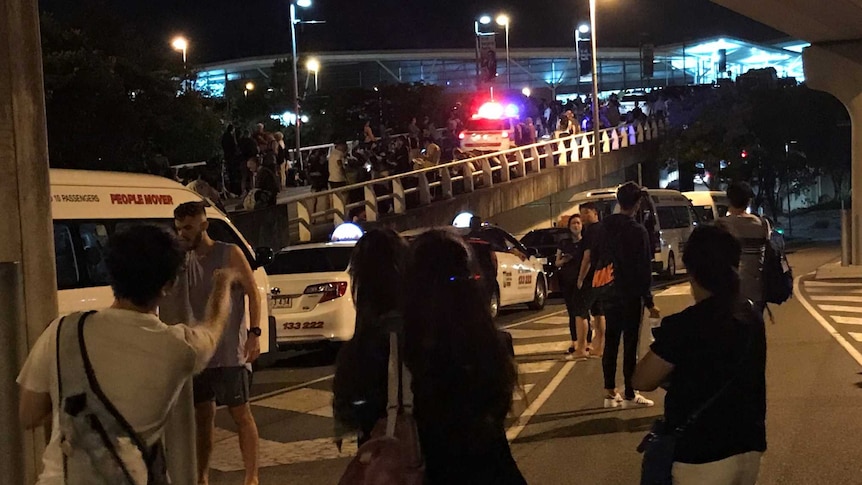 Crowds gather and traffic is backed up outside brisbane airport