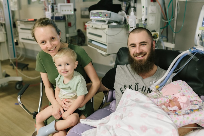 A mum and dad with their young son and baby daughter in hospital.