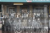 Group image of men, some in military uniforms, pictured outside a hotel in 1916, over an image from the same location.